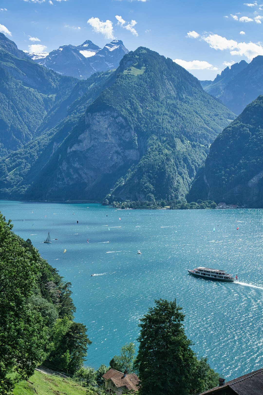 Panoramablick auf einen Schweizer Alpensee mit Bergen und Villen am Ufer